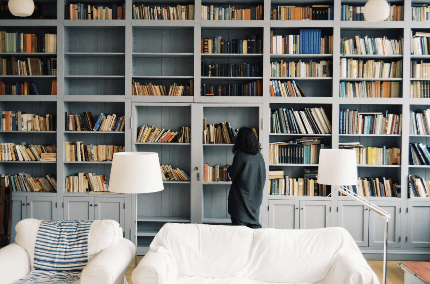 woman searching bookshelf