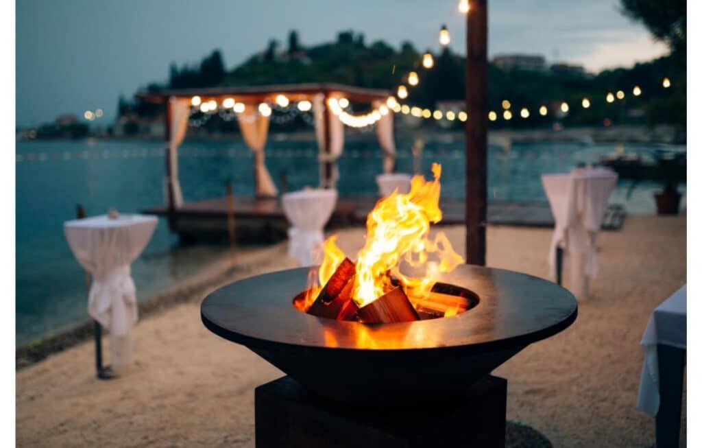 metal fire pit with a fire burning at sunset. 