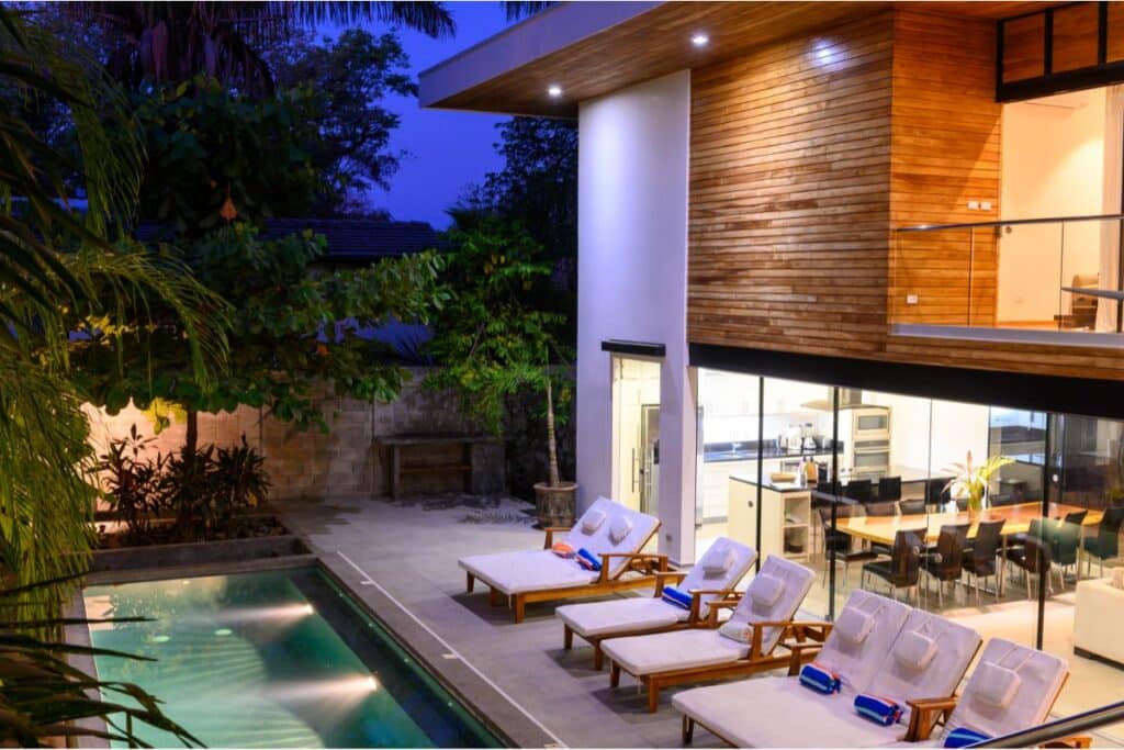 Modern house backyard with pool and lounge chairs